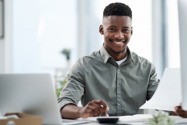 Man sitting with computer and paperwork